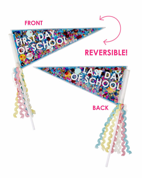 Two pennants with multi-colored confetti trapped inside lie against a white background. On one, it reads "First Day of School," and on the other it reads, "Last Day of School." Above the first pennant is reads, "Front" and below the second one it reads, "Back" in bright pink text. Pink, yellow, white, and blue tassels hang off both pennants. 