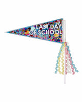 A pennant filled with multi-colored confetti with text on it that reads, "Last Day of School." On the stick, several pink, yellow, blue and white strands hang off.