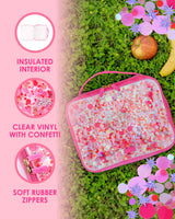 A pink, confetti-filled lunchbox lays on a bed of clover with an apple and banana next to it. To the left, three icons display information about the lunchbox. The first icon reads, "Insulated interior." The second one reads, "Clear vinyl with confetti." The third one reads, "Soft rubber zippers."