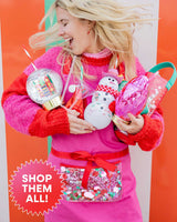 Woman holding assortment of holiday sippers and cups with text that reads, 'Shop Them All!' shot against striped wall. 