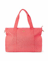 Large pink and red checkered duffel with strap up shot against white background. 