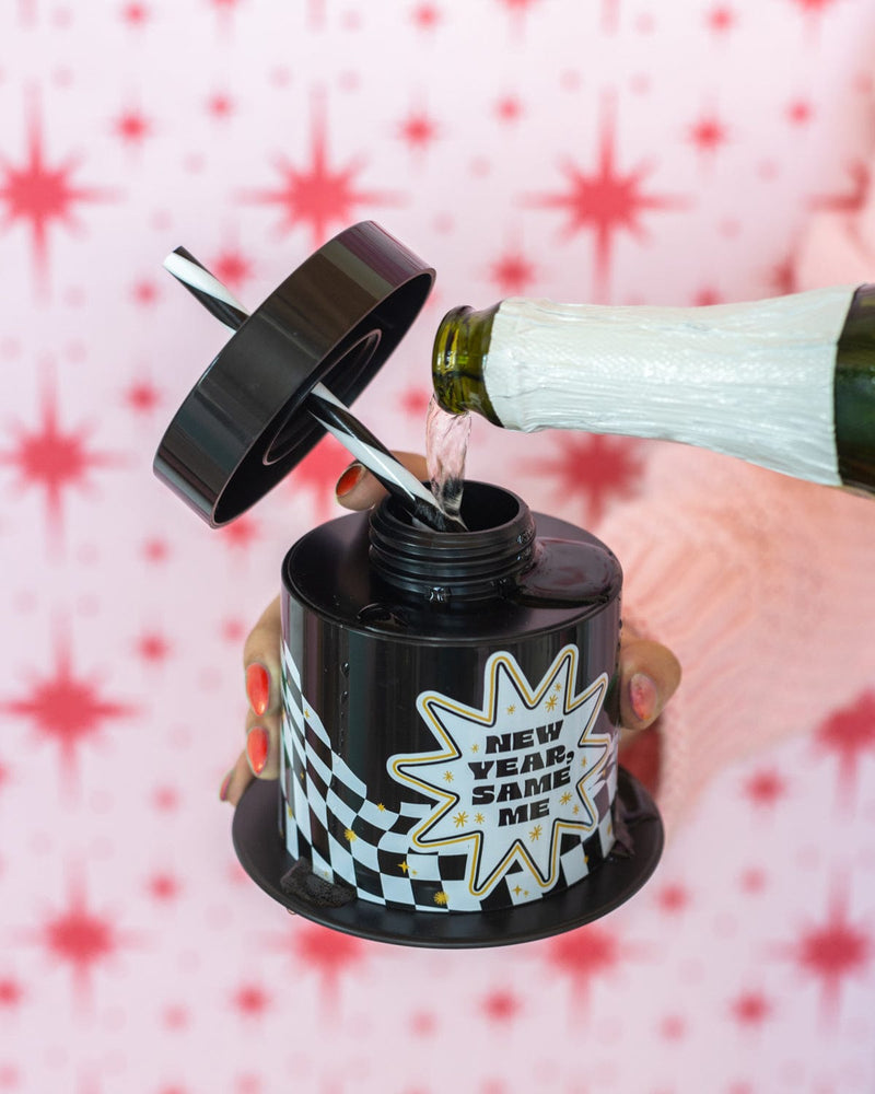 Champagne being poured into 'New Year, Same Me' Sipper shot against red and white patterned background. 