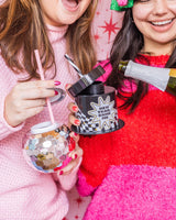 Smiling women pouring champagne into 'New Year, Same Me' and disco Sipper.