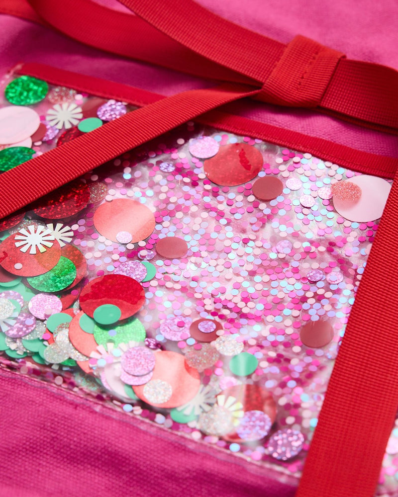 Close up of trapped confetti vinyl pocket with red, green, and pink confetti and red trim details.