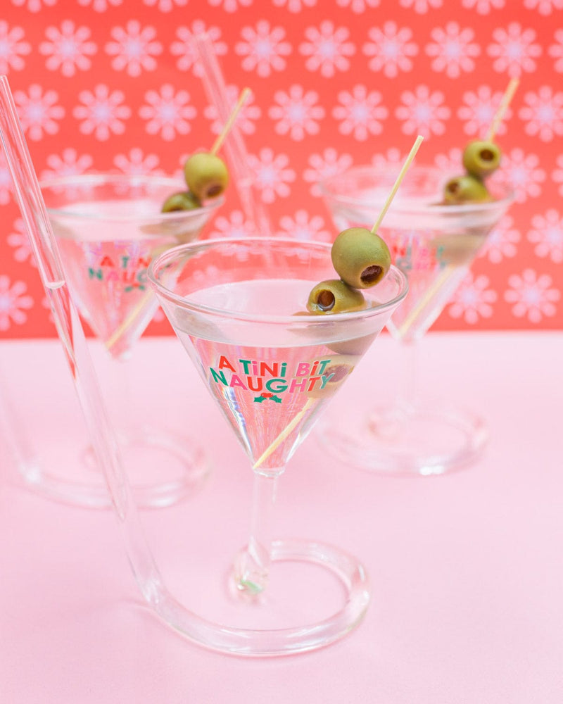 'A Tini Bit Naughty' martini glasses with olives shot against patterned wallpaper. 