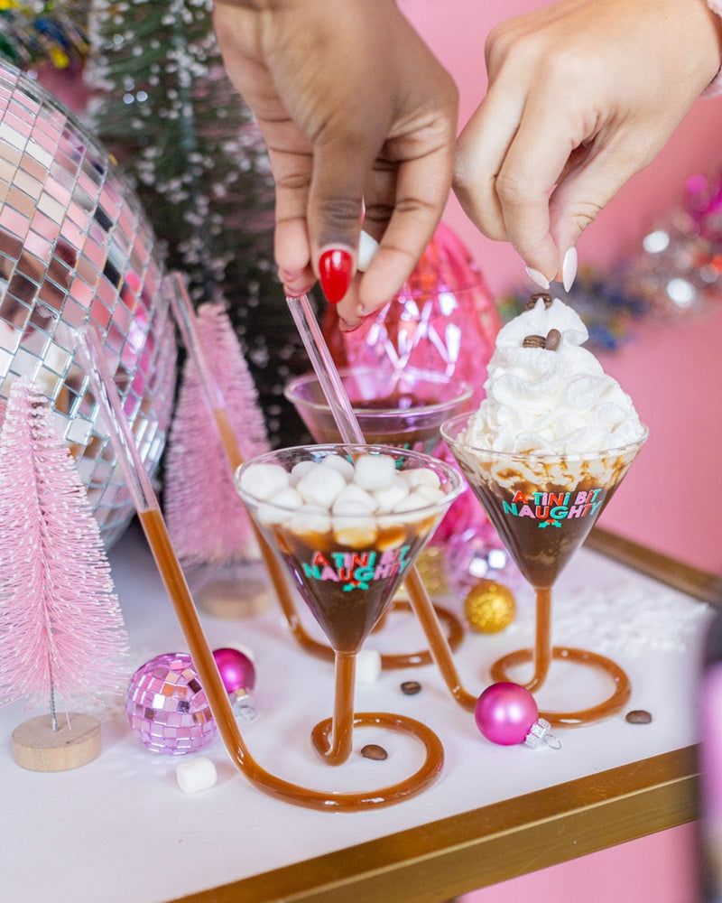 Hands adding marshmallows and coffee beans to 'A Tini Bit Naughty' martini glasses as garnishes to top off their espresso martinis