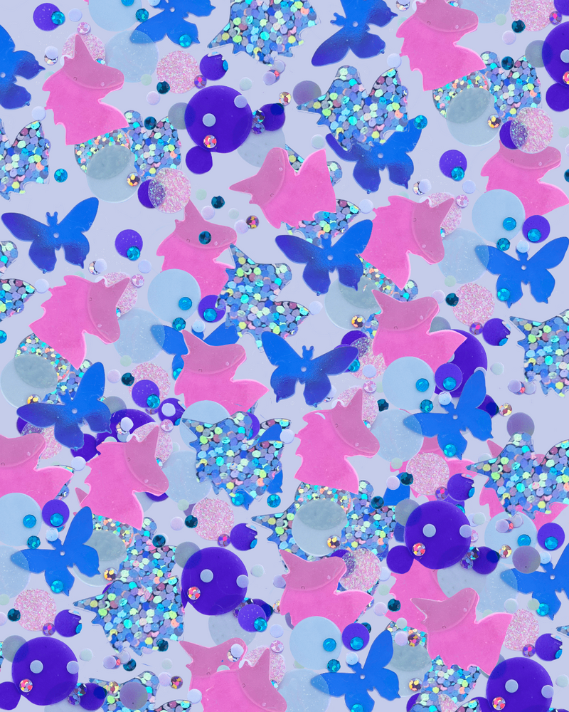 Zoomed in photo of the "Unicorn Confetti." The confetti is pink, purple and blue and is shaped like unicorns and butterflies. 