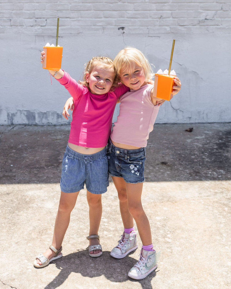 Girl friends, holding up Thanksgiving cups cheers.